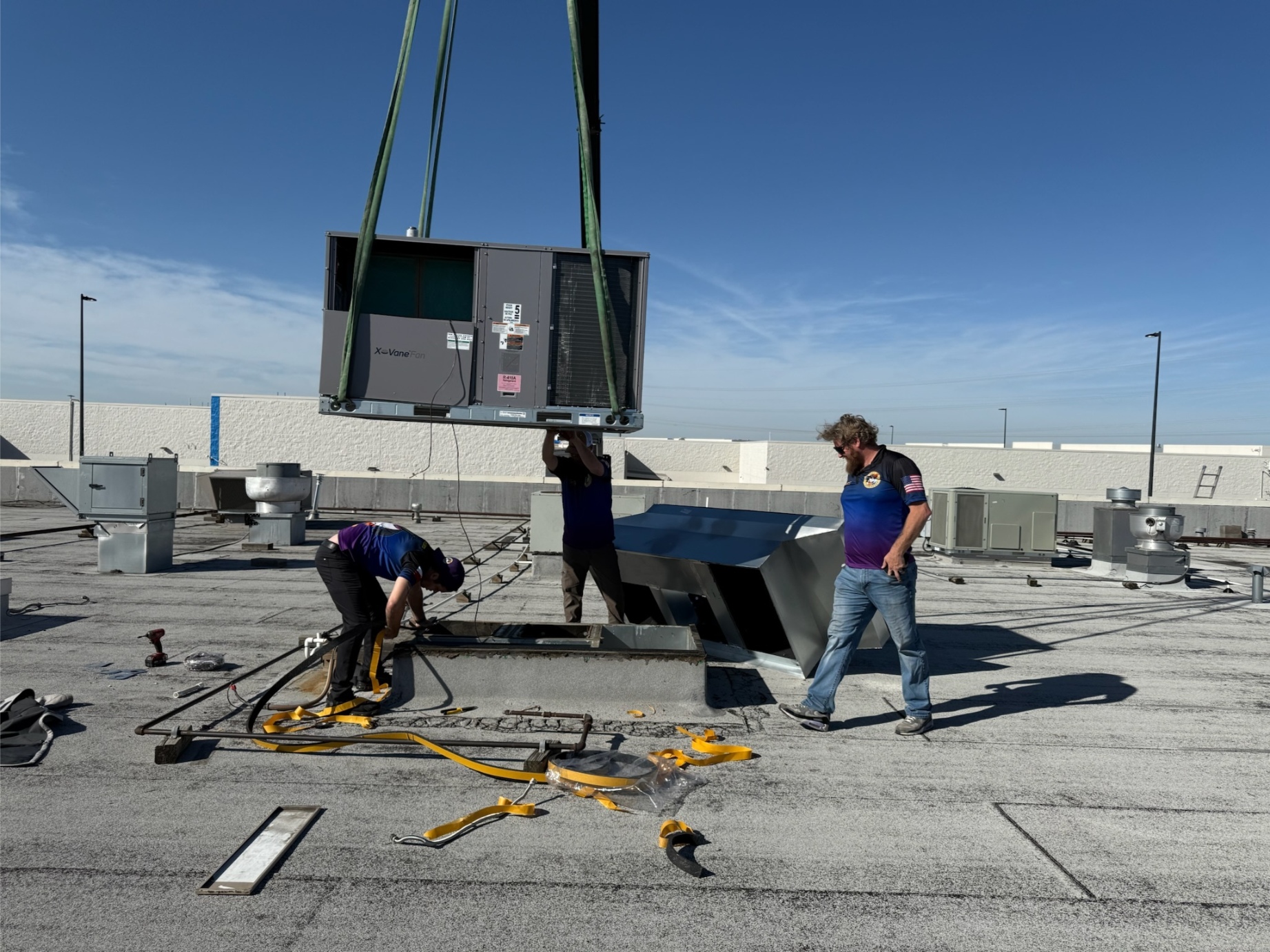 Rock Hard Refrigeration technicians installing rooftop HVAC unit with crane in North Texas