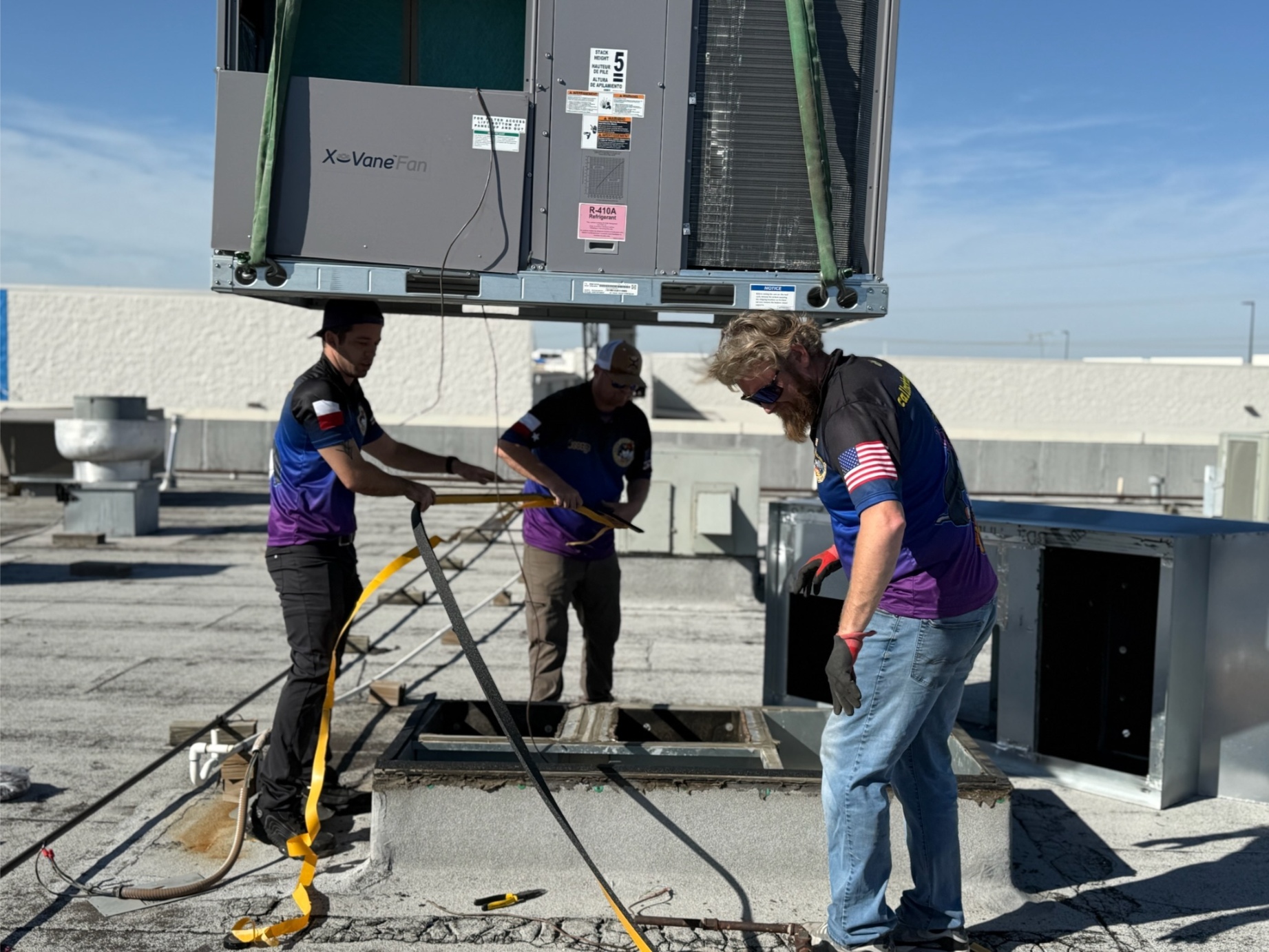 Rock Hard team securing rigging straps under crane during RTU installation